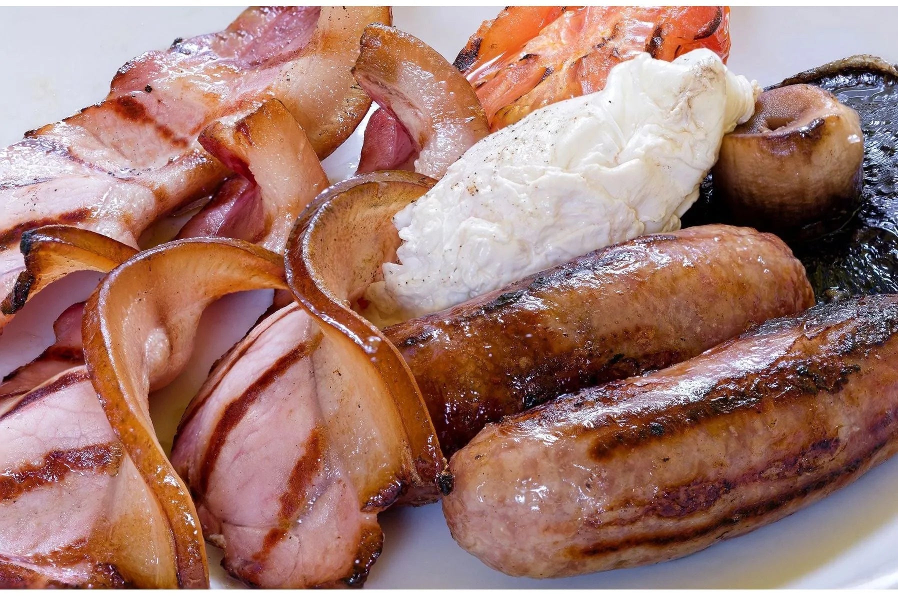 Dry cured back bacon from Primrose Herd, showing slices of fresh, high-quality pork bacon with a lean and meaty appearance.