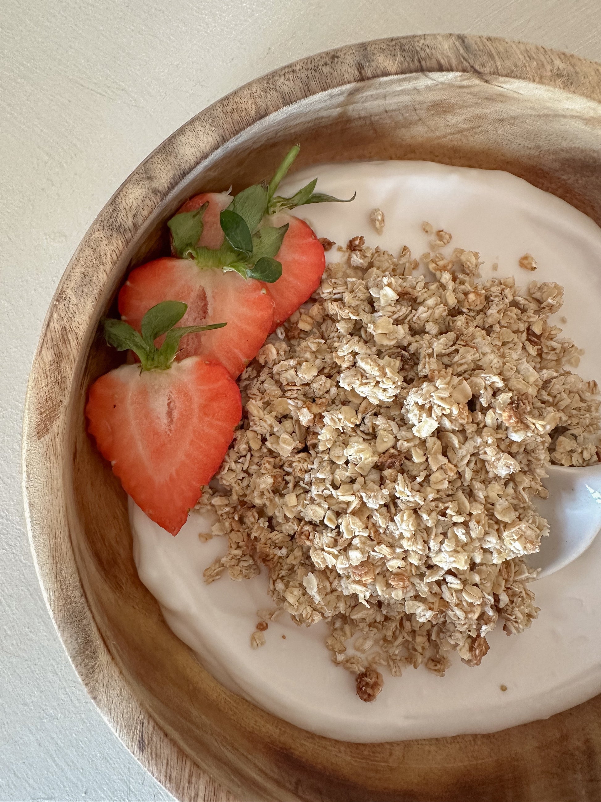 Honey and vanilla granola from Gurt Lush Food Co displayed in a bowl with visible clusters and a drizzle of honey on top.