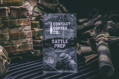 ArtisanBox Battle Prep Coffee mug with logo and bold design, displayed on a wooden surface with coffee beans nearby.