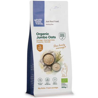 Organic jumbo oats in a clear bowl, showcasing whole cereal oats from Whole Food Earth on a neutral background.