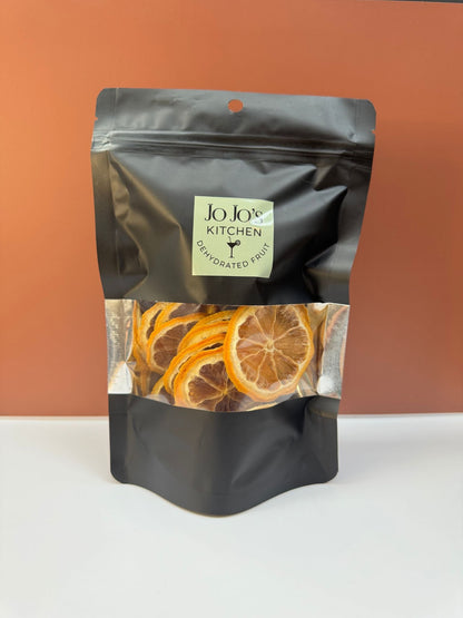 Dried lemon slices from JoJo’s Kitchen arranged in a stack, showcasing thin, dehydrated citrus with bright yellow color and textured surface.