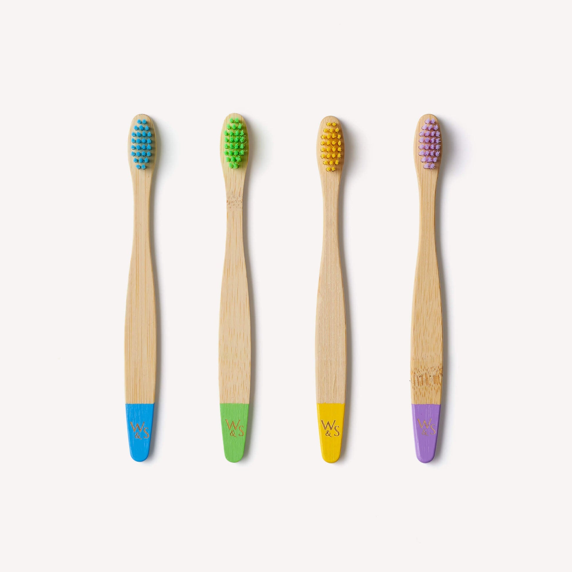 Children's bamboo toothbrushes in a 4-pack with multi-color handles, eco-friendly and suitable for kids, by Wild And Stone.