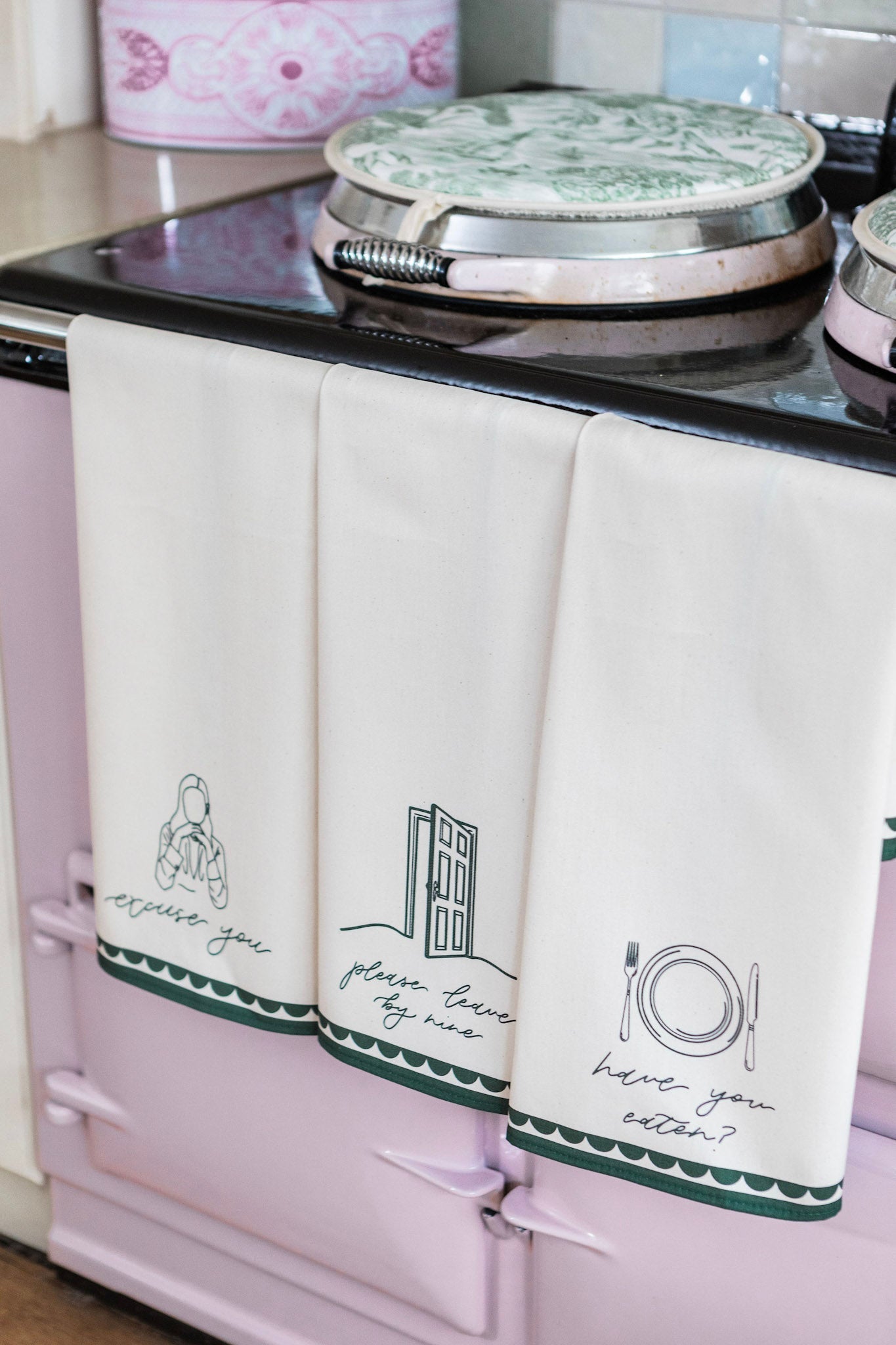 Avalon Home UK "Please Leave By Nine" tea towel with printed text and floral design, hanging on a kitchen hook.