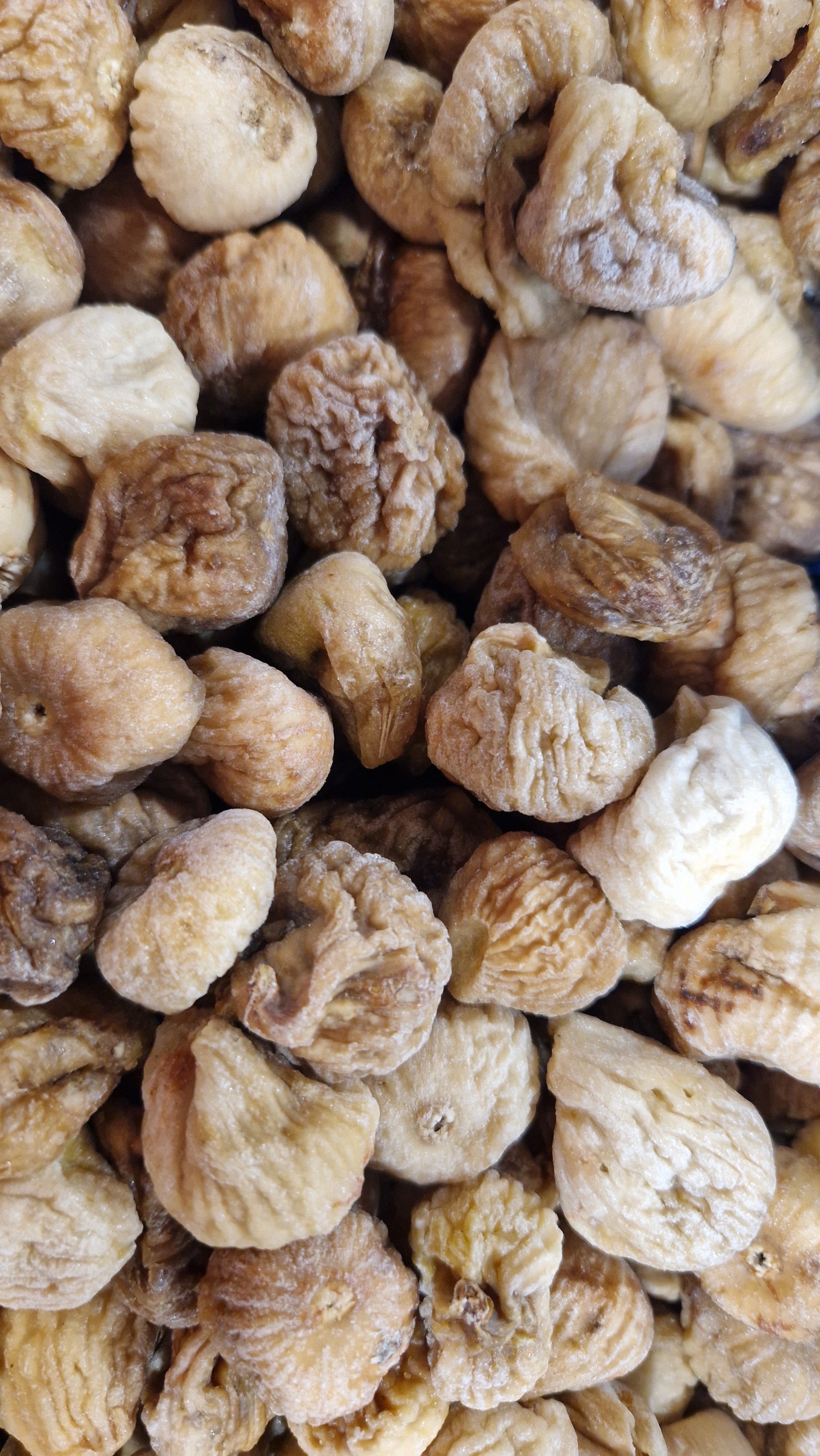 Dried baby figs snack by Whole Food Earth, close-up of small, ripe dried figs with wrinkled skin in a bowl.