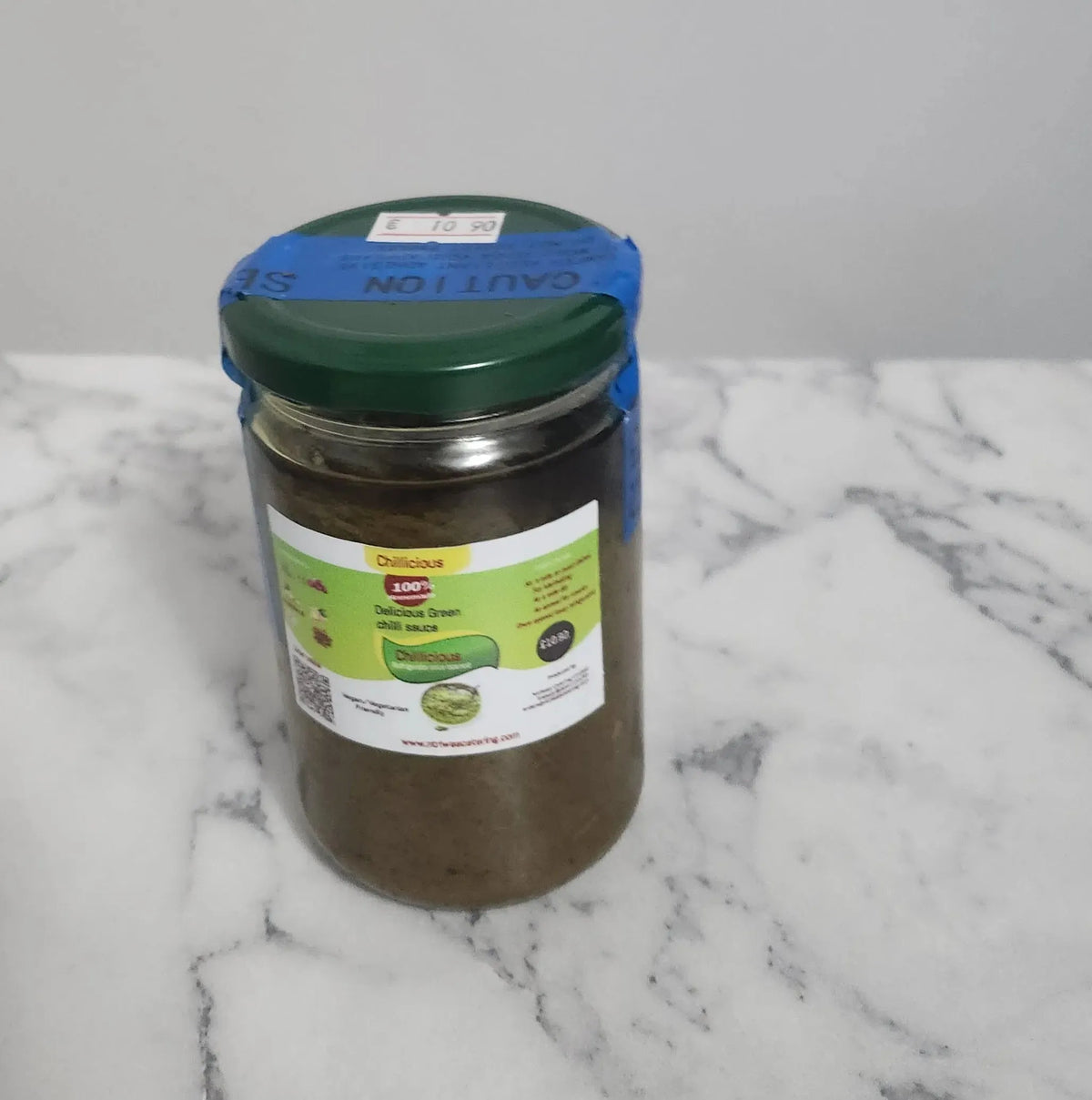 300ml bottle of Ntriwaa Catering Green Flame chili sauce, a homemade spicy chili blend for cooking and marinades.