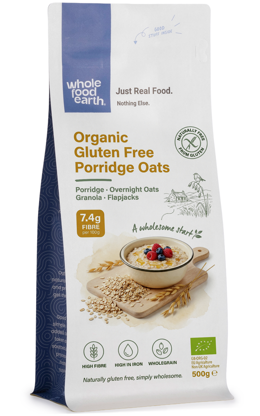 Organic gluten-free porridge oats cereal by Whole Food Earth, close-up of dry oats in a bowl with oats spilling around.