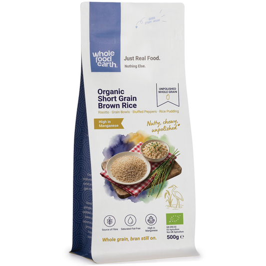 Organic short grain brown rice from Whole Food Earth, showing a bowl of cooked rice with grains and a spoon on a wooden surface.