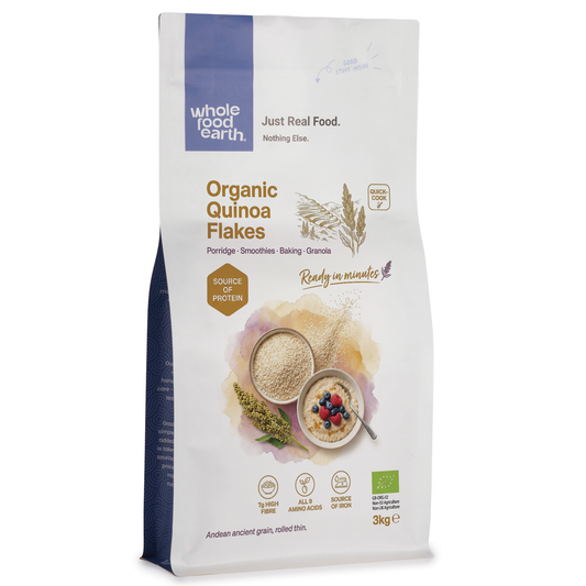 Organic quinoa flakes cereal by Whole Food Earth shown in a bowl with some flakes scattered nearby.