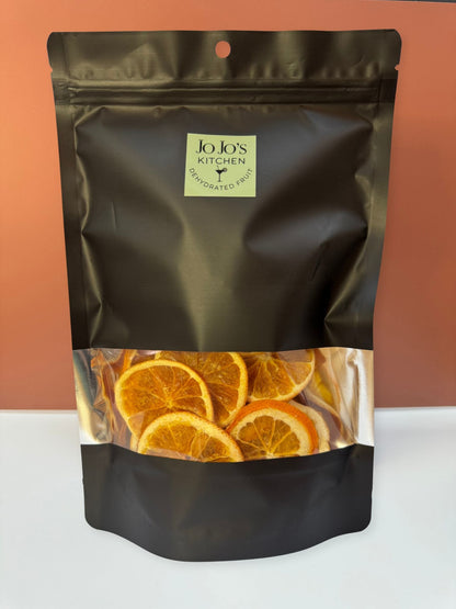 Dehydrated orange slices from JoJo’s Kitchen, close-up of vibrant dried citrus pieces on a white background.