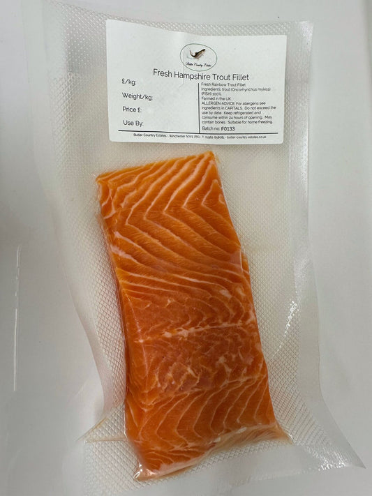 Fresh rainbow trout fillets from Butler Country Estates, neatly arranged on a white plate, ready for online order.