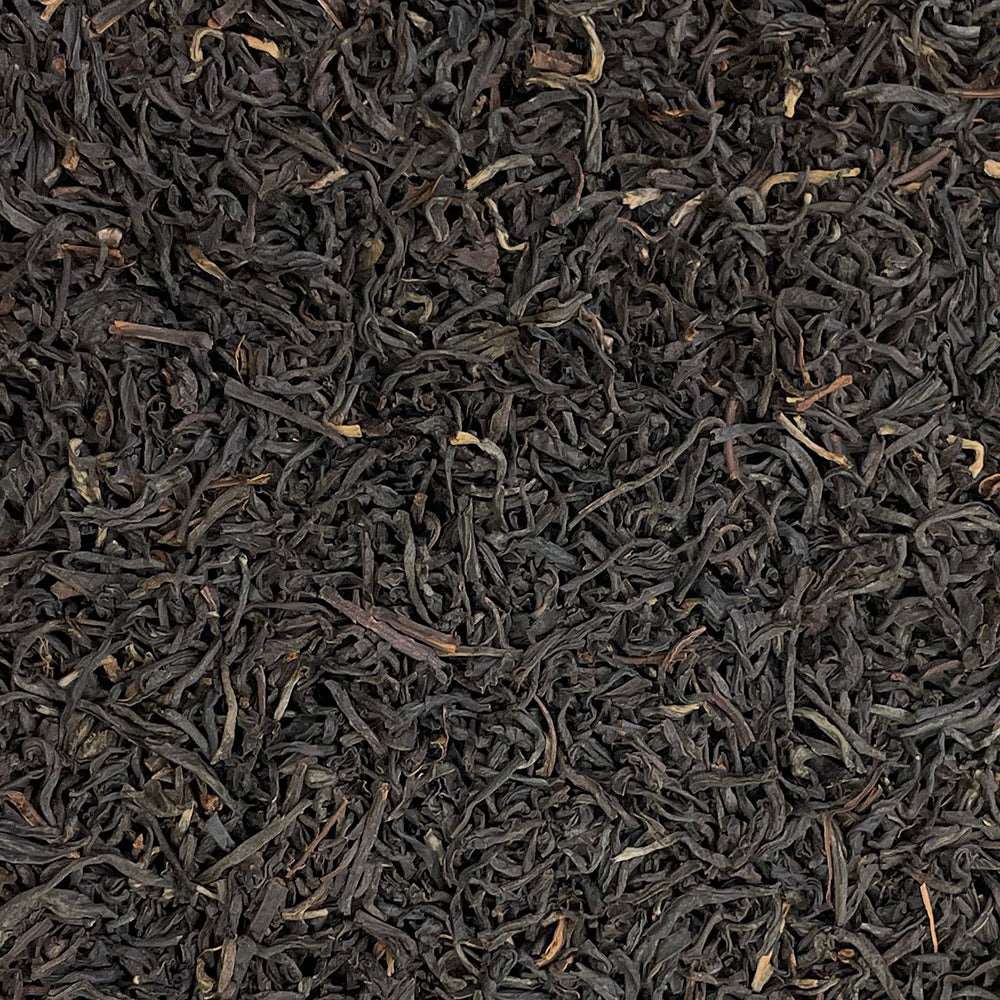 Loose leaf Assam Bukhial TGFOP tea from High Teas, showcasing golden tips and dark tea leaves in a fresh, aromatic blend.