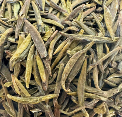 Porter Hill Tea Company's Badaling Yellow Green Tea leaves in a bowl, showcasing vibrant yellow-green tea leaves for brewing.