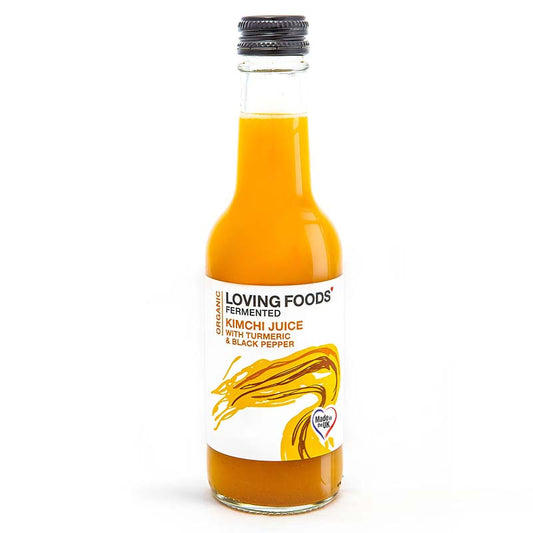Bottle of Loving Foods organic kimchi juice with turmeric and black pepper, showcasing fermented vegetable juice in a clear glass bottle