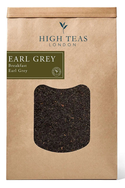A package of High Teas Breakfast Earl Grey tea with tea leaves and a steaming cup of brewed tea on a wooden table.