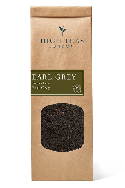 A tin of High Teas Breakfast Earl Grey tea with loose tea leaves and a steaming cup of brewed Earl Grey on a rustic wooden table.