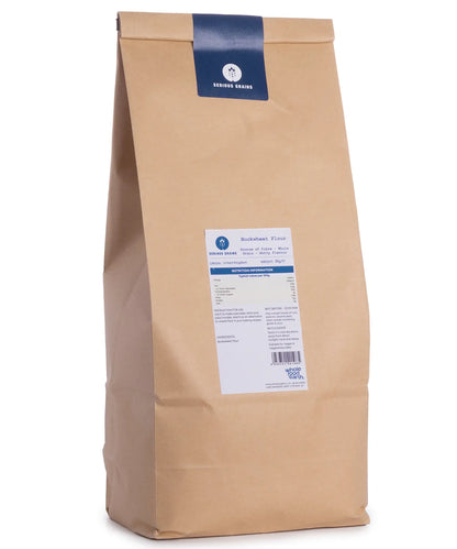 Two kilograms of Serious Grains buckwheat flour in a clear bag, showing the light brown powder inside.