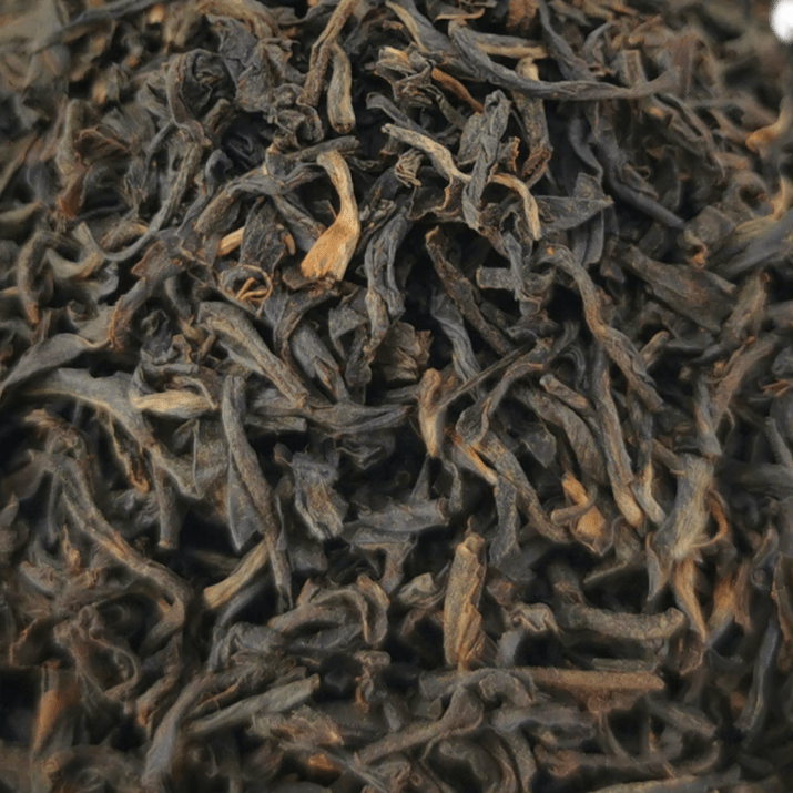 Loose leaf Bukhial Assam TGFOP black tea from Porter Hill Tea Company, showcasing dark, fragrant tea leaves in a clear container.