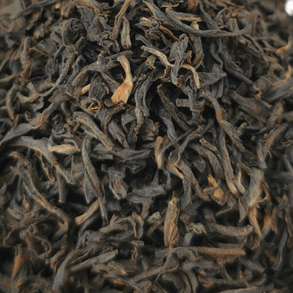 Loose leaf Bukhial Assam TGFOP black tea from Porter Hill Tea Company, showcasing dark, fragrant tea leaves in a clear container.