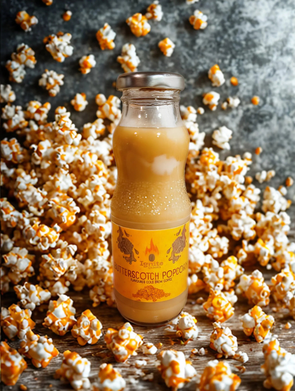 Creamy butterscotch popcorn-inspired cold brew coffee in a clear glass, served with ice and a straw.