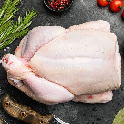 Whole Creedy Carver free-range chicken from Primrose Herd, fresh and plump with golden skin, ready for cooking.