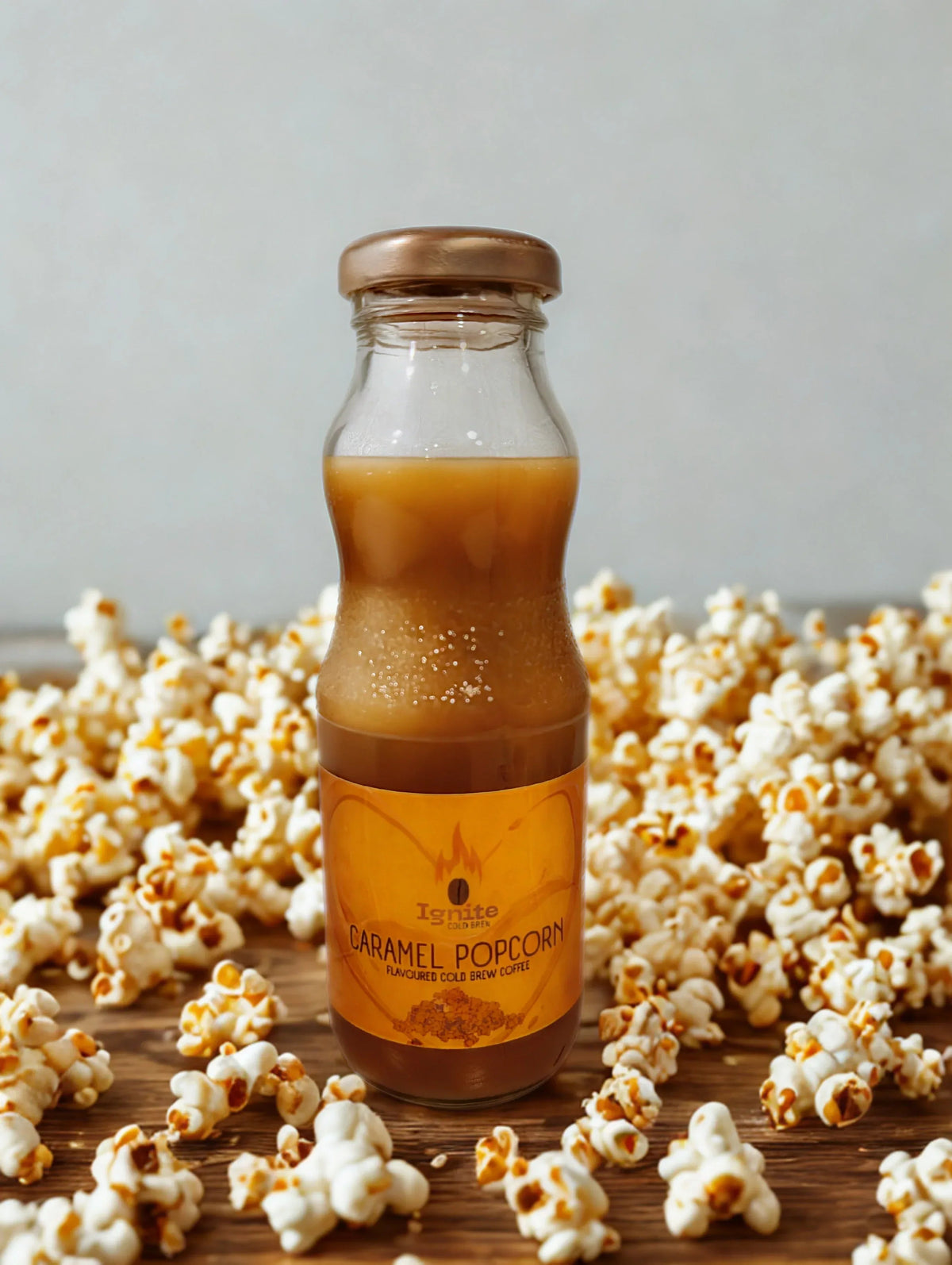 Creamy caramel popcorn-inspired cold brew coffee in a clear glass with whipped cream and caramel drizzle, served cold.
