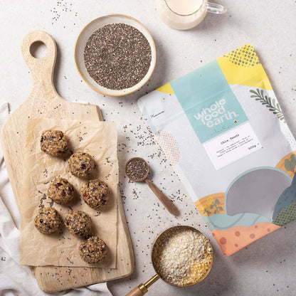 Whole Food Earth chia seeds in a jar, with chia seeds scattered on a wooden surface, showcasing the healthy superfood.