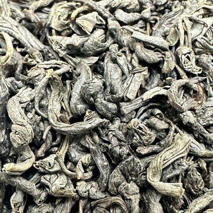 Porter Hill Tea Company Chunmee green tea leaves in a clear jar, showcasing the twisted, light green tea leaves for brewing.