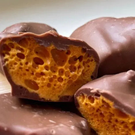 Handmade milk chocolate cinder toffee and honeycomb by Gorvett & Stone, showing golden toffee pieces coated in smooth chocolate.