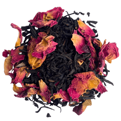 Brewing Keemun Rose black tea by Porter Hill Tea Company in a teapot with a cup and tea leaves on a wooden table.