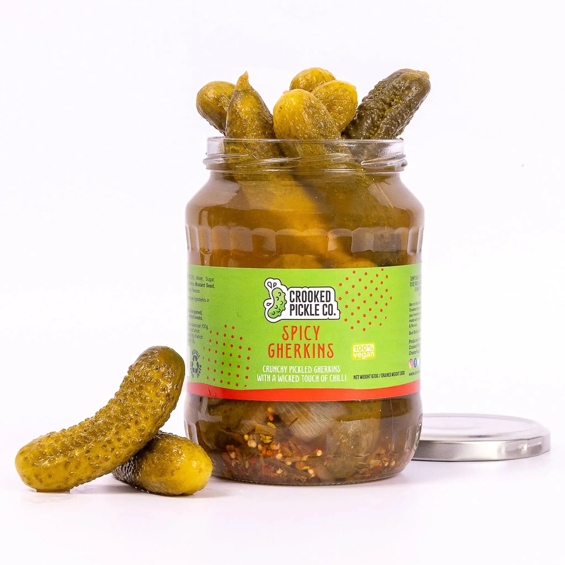 Jar of Crooked Pickle Co. spicy gherkins pickles with bright green cucumbers and spicy seasoning visible in the jar.