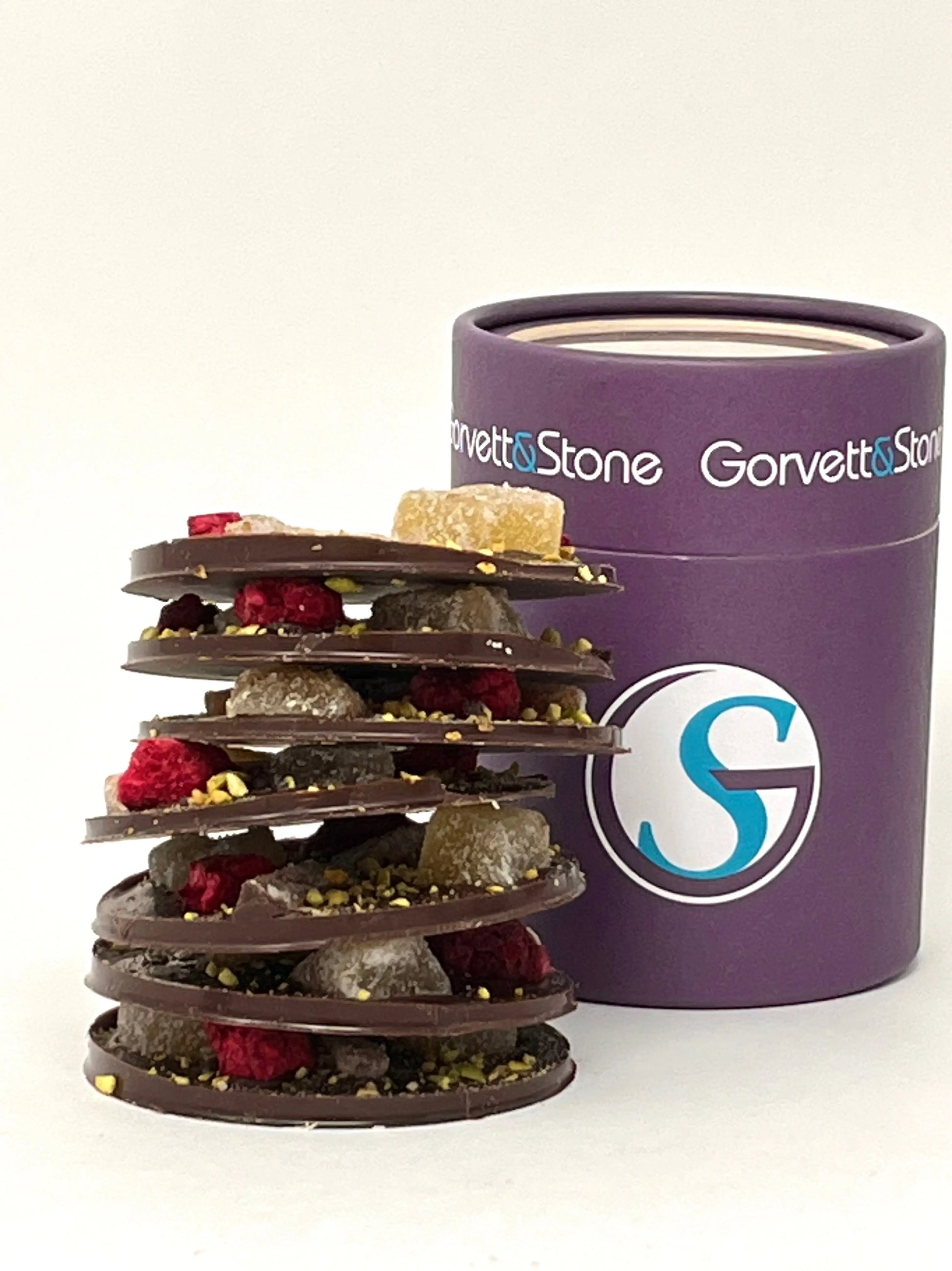 Stack of Gorvett & Stone dark chocolate mendiants with mixed fruits and nuts, showcasing a variety of chocolate-covered treats.