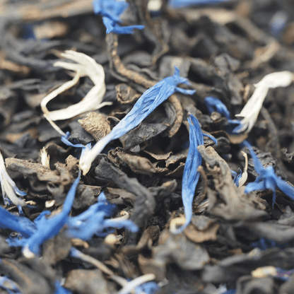 Decaf Earl Grey black tea from Porter Hill Tea Company in a teacup with tea leaves and citrus peel garnishes.