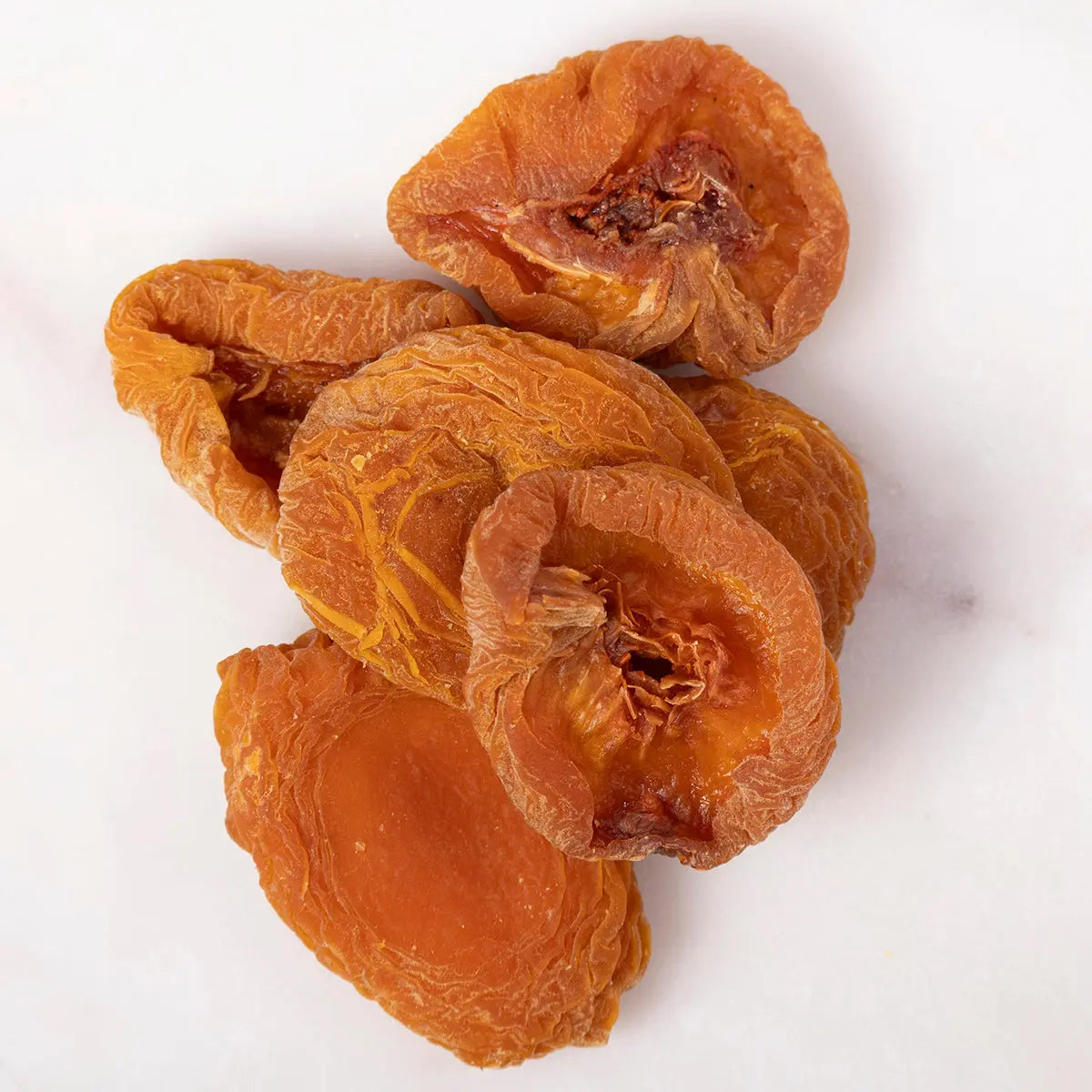 Dried peach halves from Whole Food Earth, showing vibrant orange dried fruit slices on a white background.
