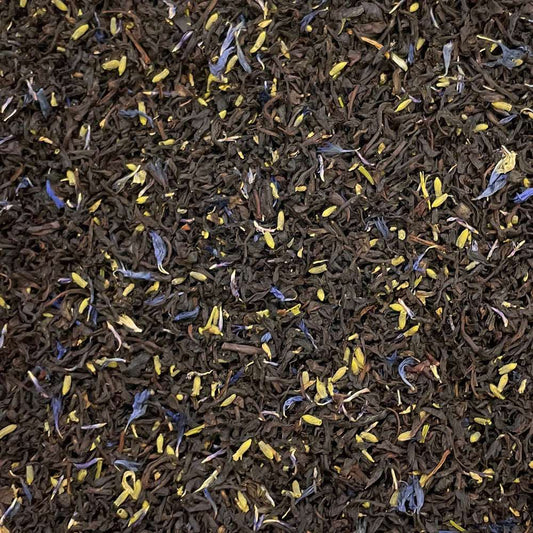 Loose leaf Earl Grey Reserve tea with cornflowers from High Teas, shown in a clear glass teapot with tea leaves and flowers.