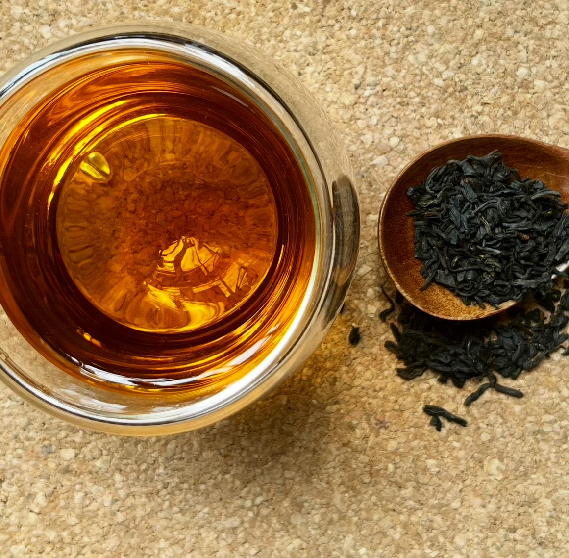 Black tea called Emperor Butterfly Lapsang Souchong by Porter Hill Tea Company, shown in a close-up of tea leaves.