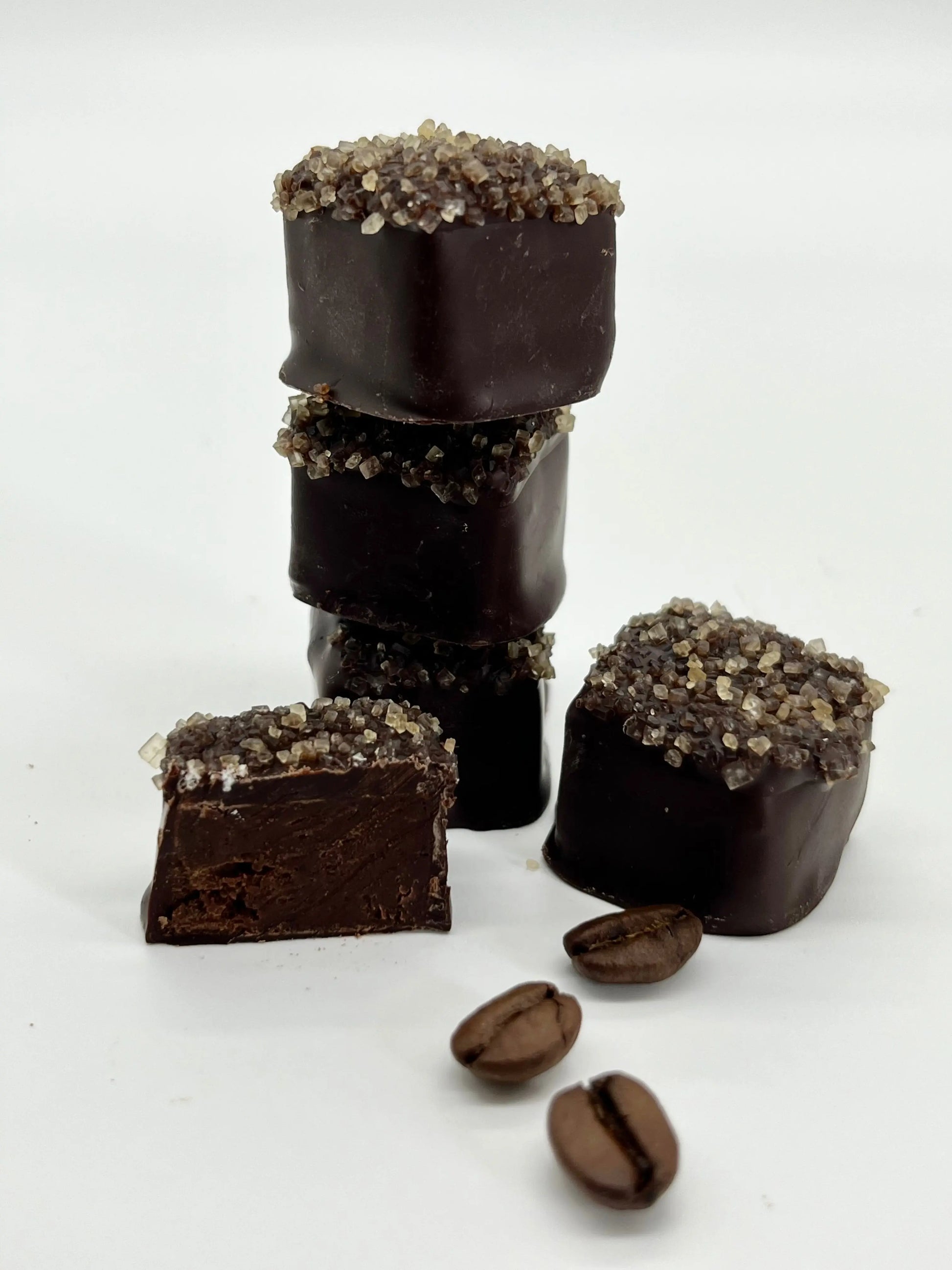 Stack of dark chocolate espresso candies from Gorvett & Stone, showcasing glossy, rich chocolate with a smooth espresso filling.