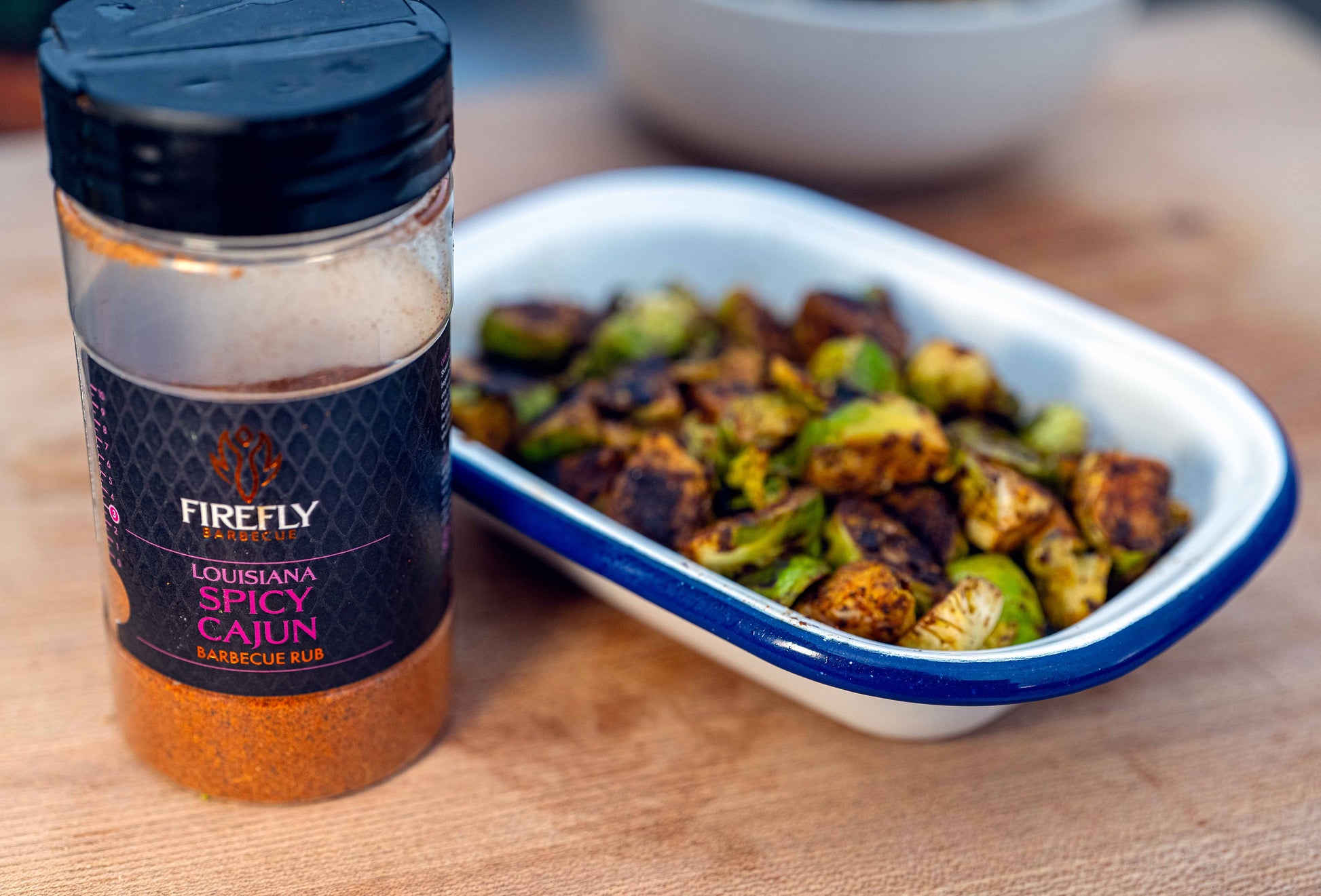 FireFly Barbecue Louisiana Spicy Cajun BBQ Rub on fresh sprouts, showcasing vibrant seasoning with red pepper flakes and herbs.