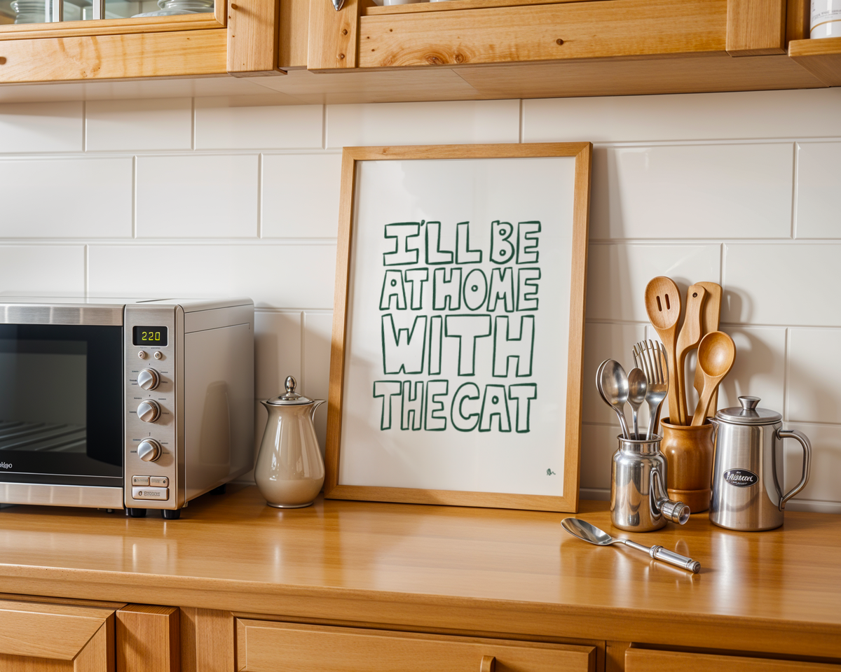 Green minimalist typography print poster with the phrase "I'll Be At Home With The Cat" by Peak Prints, displayed in a frame.