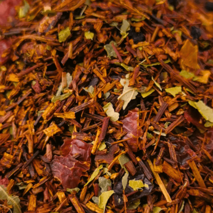 Porter Hill Tea Company Fruit Rooibos tea in a clear glass cup, showcasing vibrant red and orange hues of the herbal infusion.
