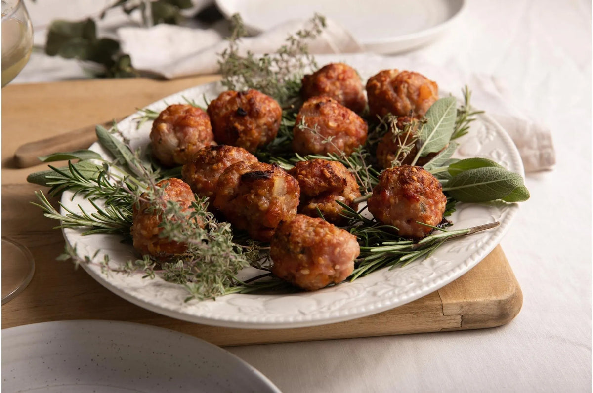 Cornish gluten-free heritage pork sausage meat from Primrose Herd shaped into sausage meat balls on a white background.