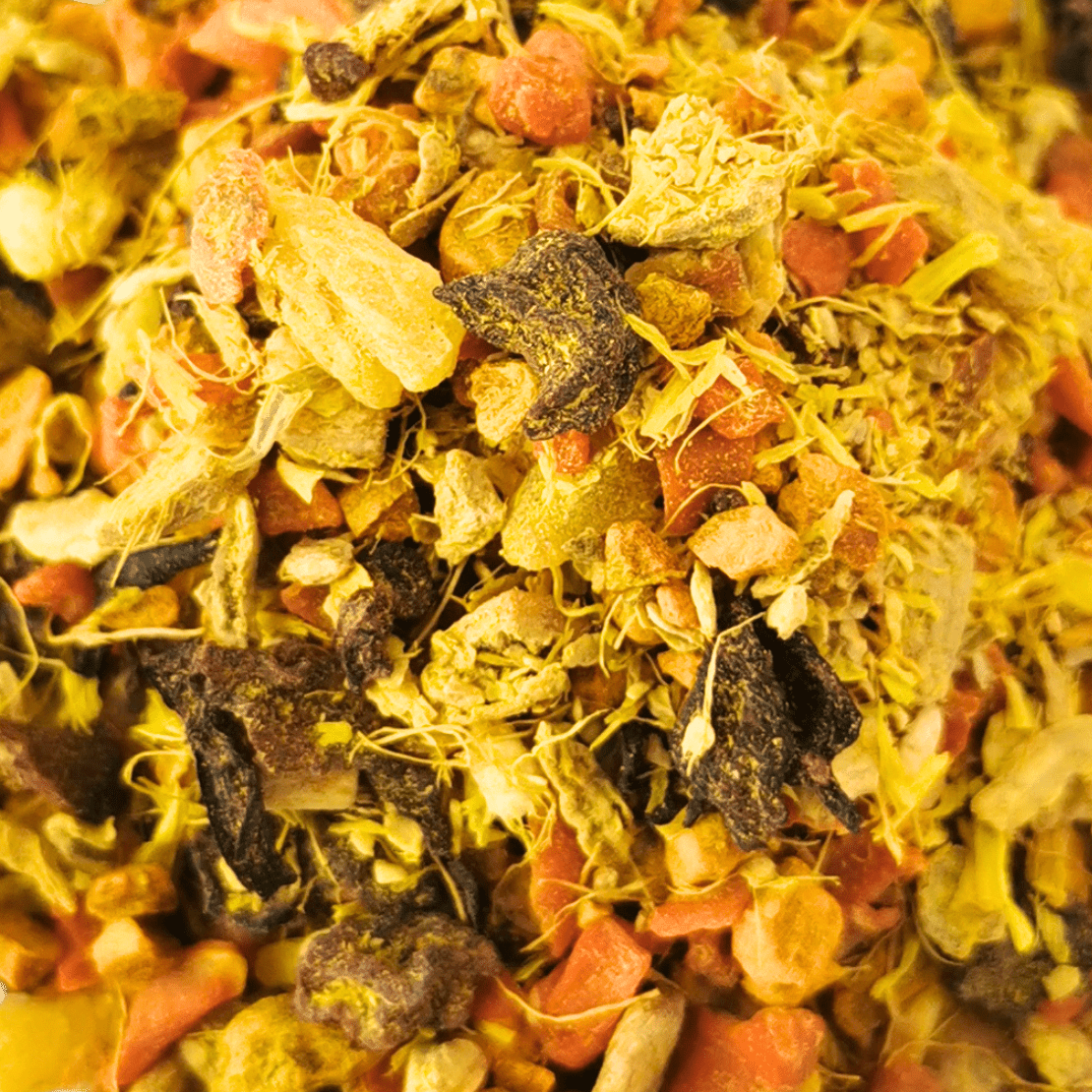 Porter Hill Tea Company's Glow fruit and herbal tea blend in a clear glass cup with colorful dried herbs and fruit pieces.