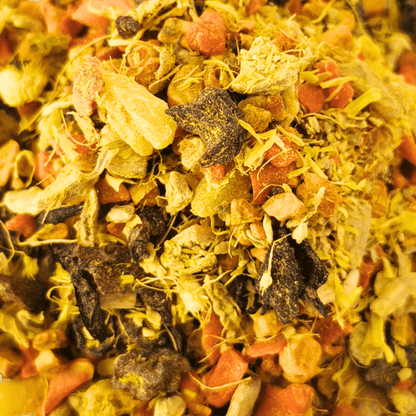 Porter Hill Tea Company's Glow fruit and herbal tea blend in a clear glass cup with colorful dried herbs and fruit pieces.