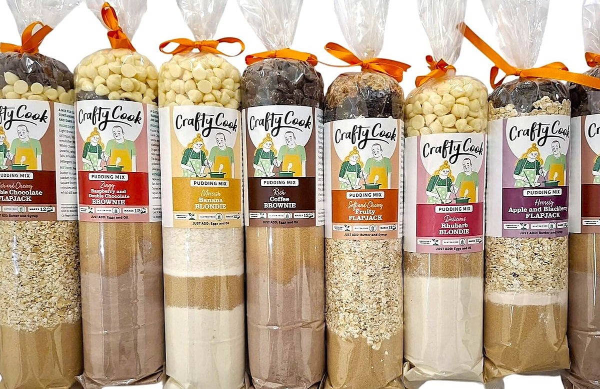 Assorted gluten-free puddings from Crafty Cook, displayed in a group shot with various creamy dessert flavors.