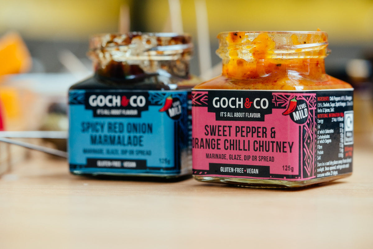 Sweet pepper and orange chili chutney by Goch & Co in a jar, showcasing vibrant orange and red colors.