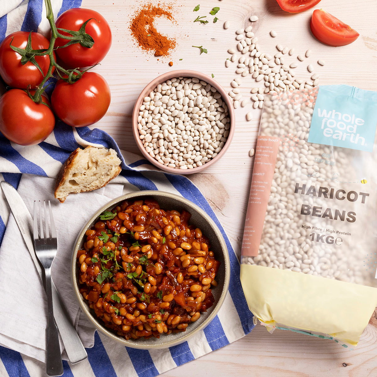 A bowl of cooked haricot beans on a wooden table, showcasing Whole Food Earth beans and pulses in a natural setting.