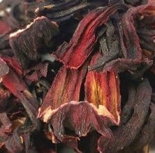 Bright cup of Porter Hill Tea Company's organic hibiscus herbal tea with vibrant red hibiscus blossoms and brewed herbal leaves.