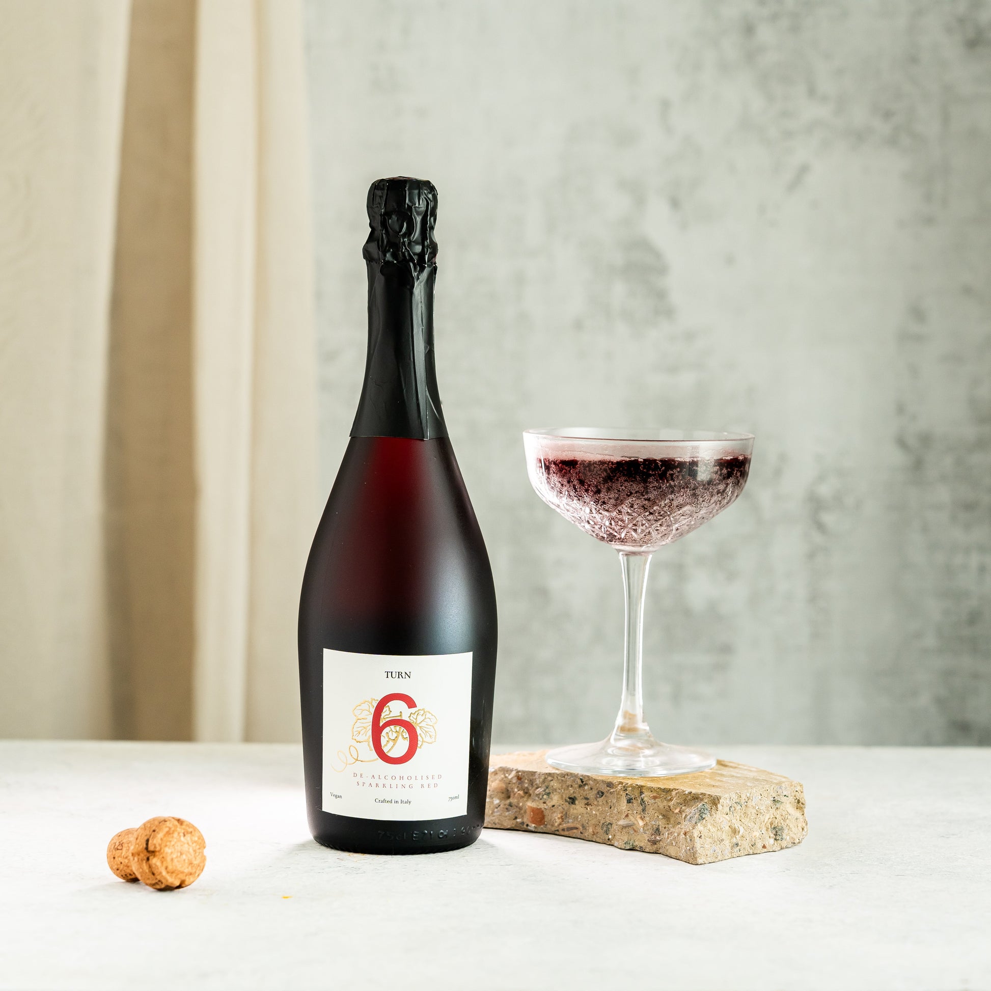 Glass of alcohol-free sparkling red wine from Turn 6, showcasing vibrant red color and sparkling bubbles in a high-resolution image.