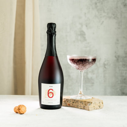 Glass of alcohol-free sparkling red wine from Turn 6, showcasing vibrant red color and sparkling bubbles in a high-resolution image.