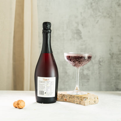 High-resolution image of Turn 6 Premium Alcohol-Free Sparkling Red Wine in a glass, showcasing its vibrant red color and effervescent bubbles.