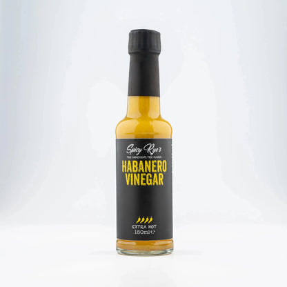 Spicy Ryes habanero vinegar in a clear glass bottle, showing bright orange habanero peppers and liquid inside.